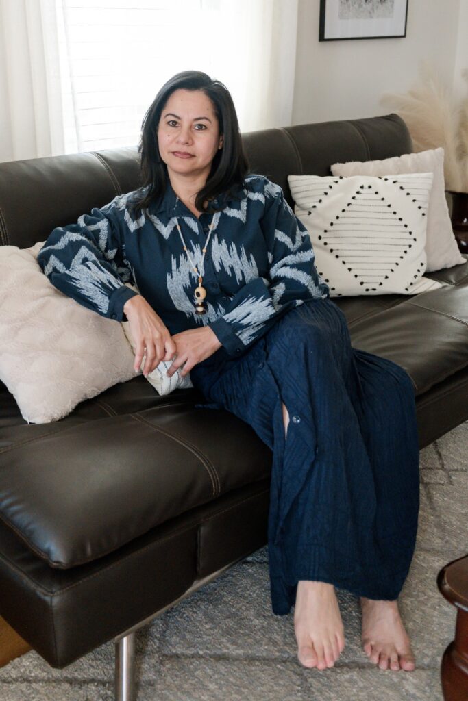 High performance entrepreneur Vida DeOlivier sitting on the couch thinking to solve a problem.